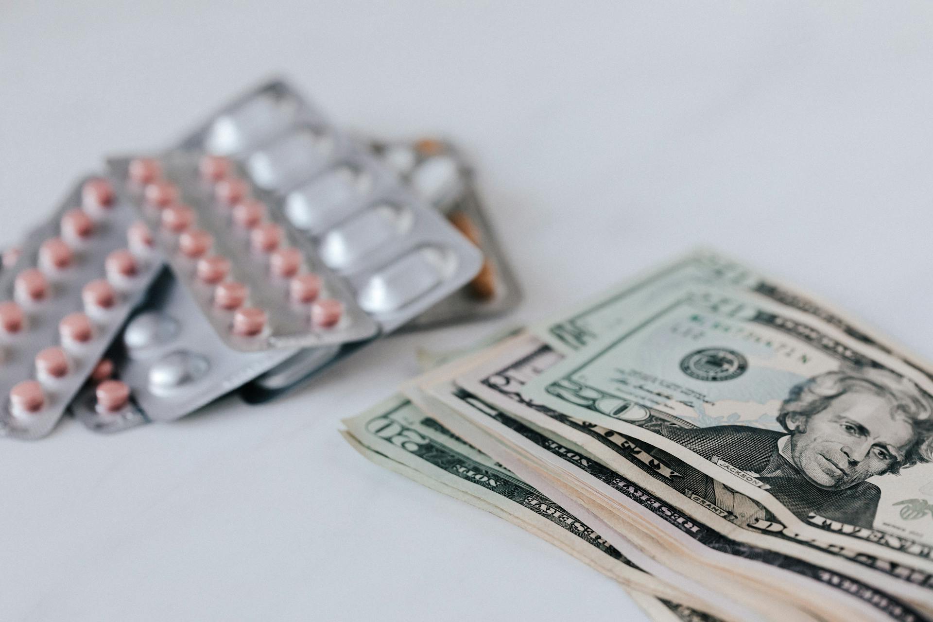 Pile of money near set of multicolored pills