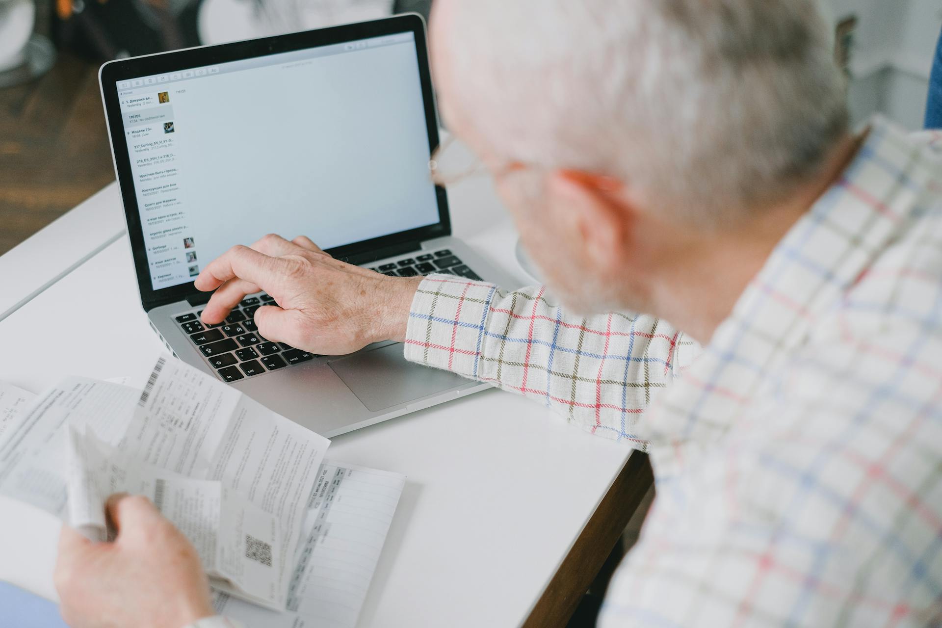 Senior man with bills and laptop 