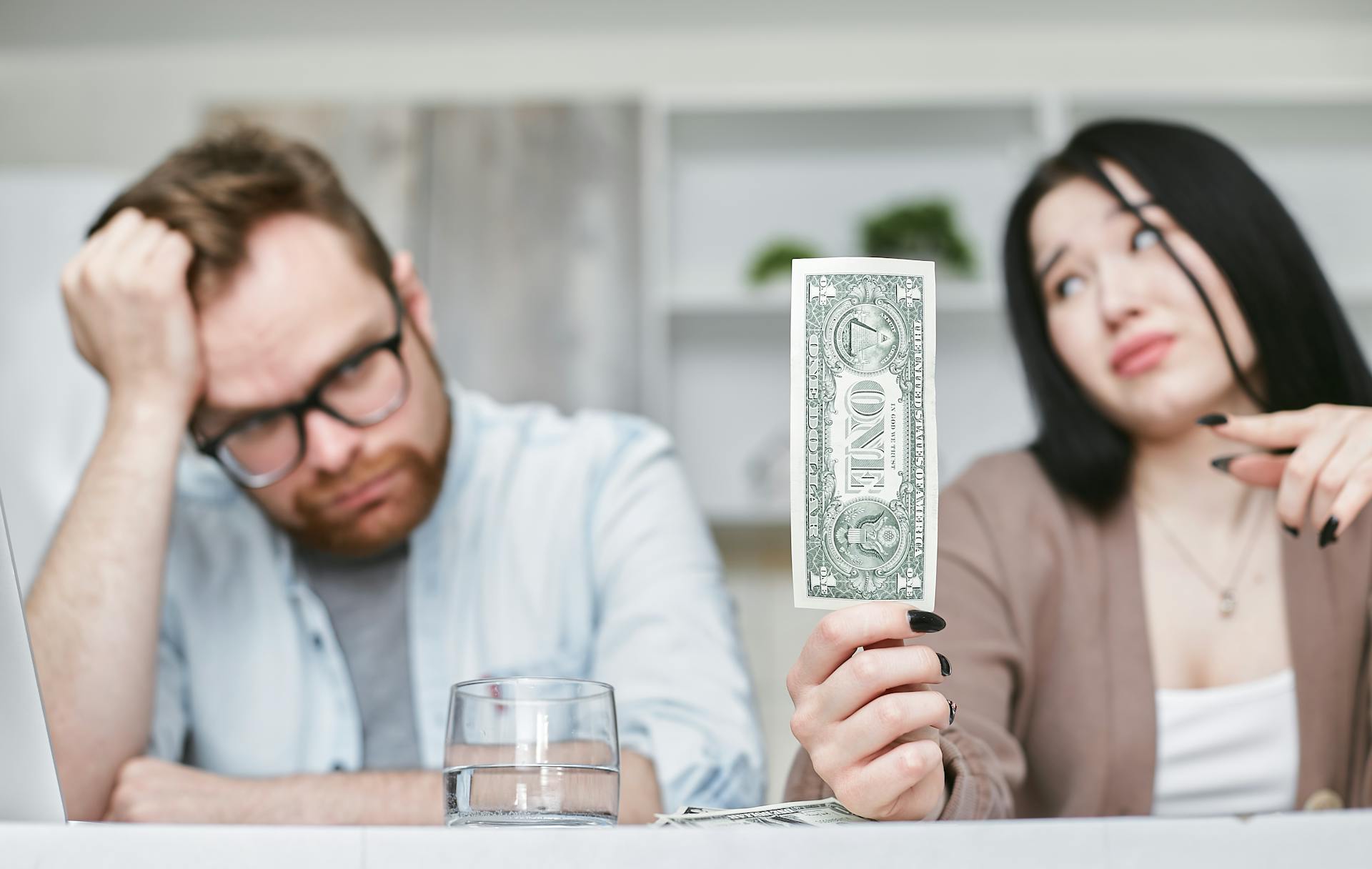Couple Sitting at the Table with Money Trouble 