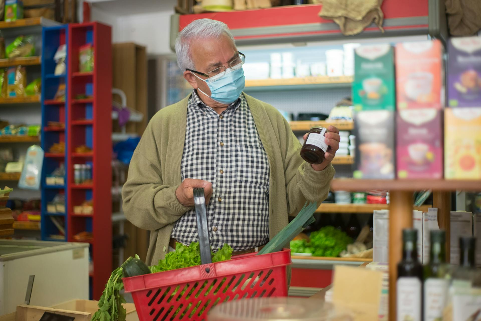 Senior Man Grocery Shopping Reading Label in Bottle 