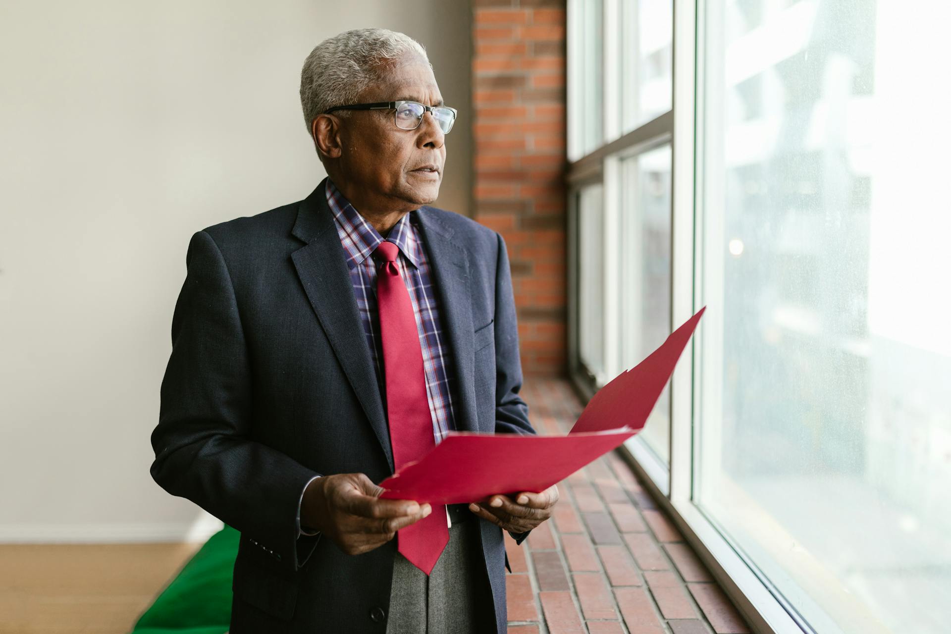 Elderly Businessman Standing near Windows
