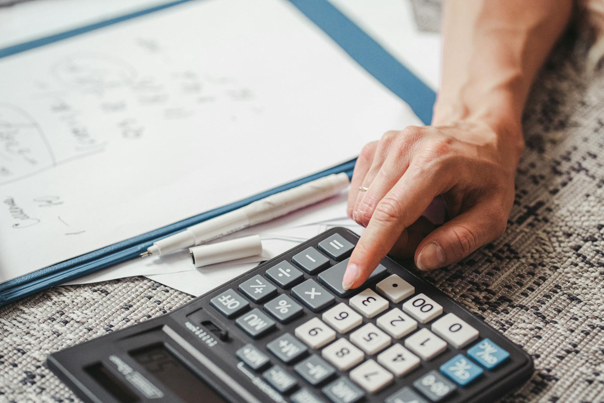 A Person Using Calculator 